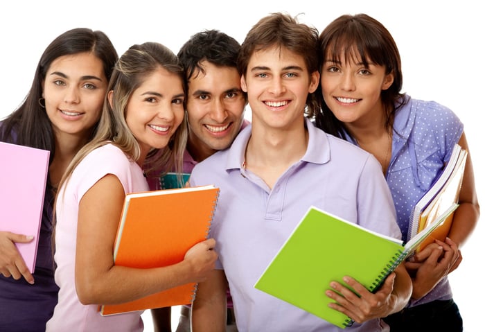 Happy group of college students with notebooks and smiling - isolated over a white background